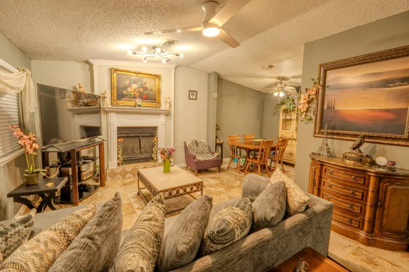 Living room with sofas, a fireplace, and warm natural finishes
